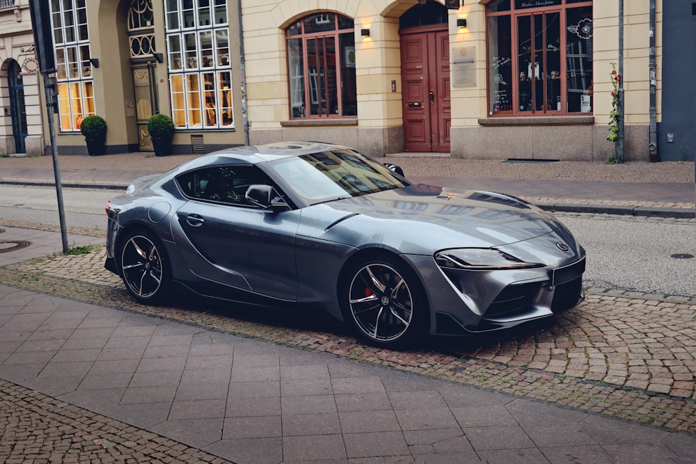 a silver sports car parked on the side of the road