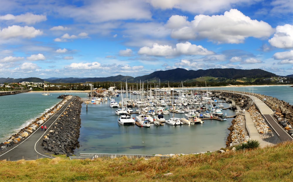 a harbor filled with lots of boats under a cloudy blue sky