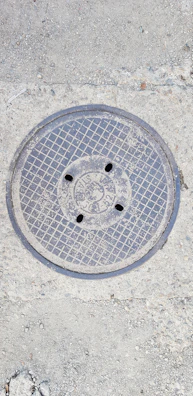 Close-up of a sturdy manhole cover with textured surface on a city street.