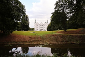 a large white house sitting on top of a lush green field