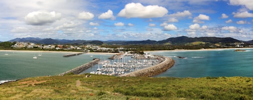 Drone video screenshot showing a panoramic view of a harbor with multiple moored boats