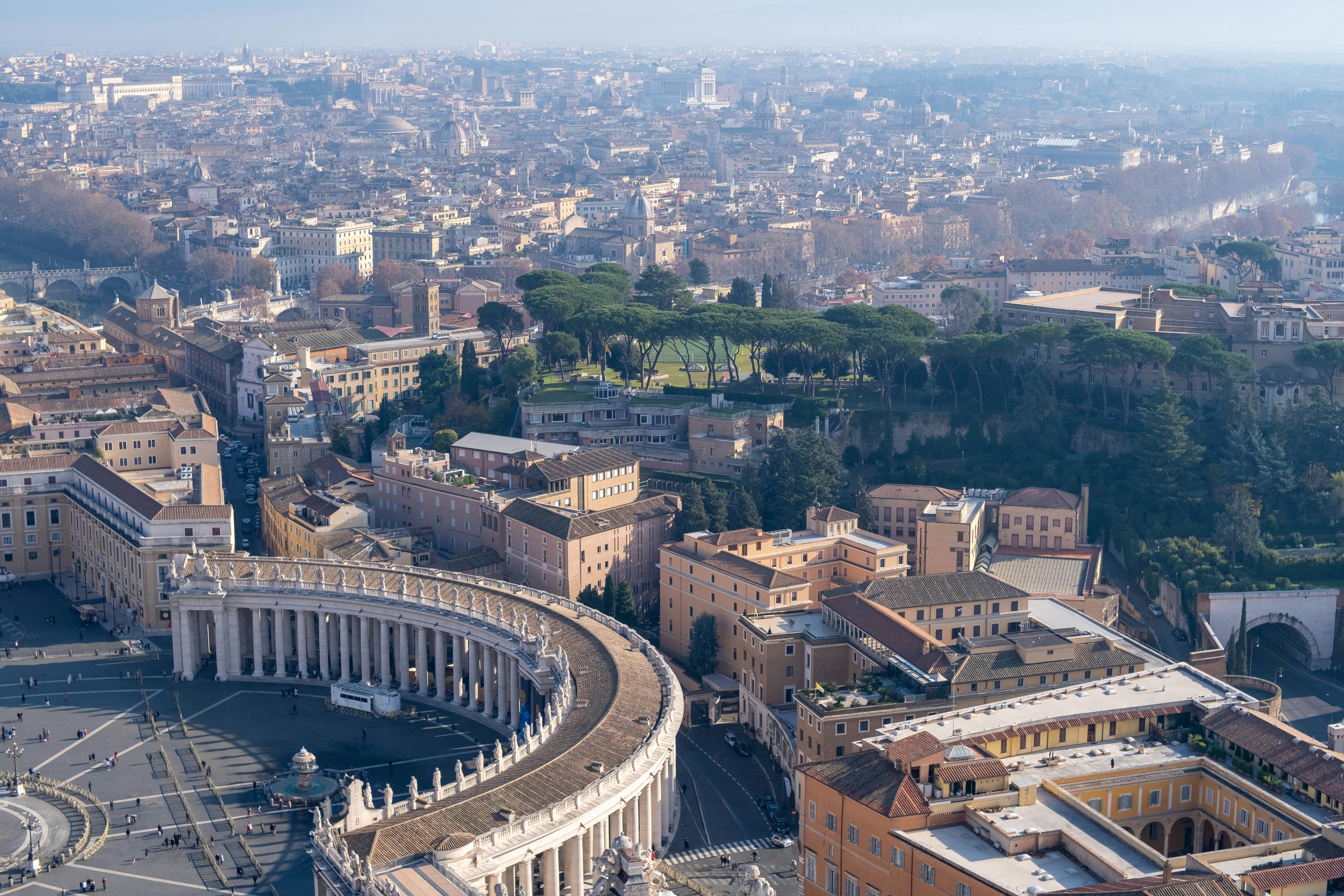 an aerial view of a city with a circular building, Shot on Fujifilm X-T3 with TTartisan 35mm f1.4