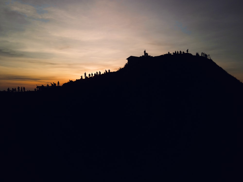 the sun is setting over a hill with trees on it