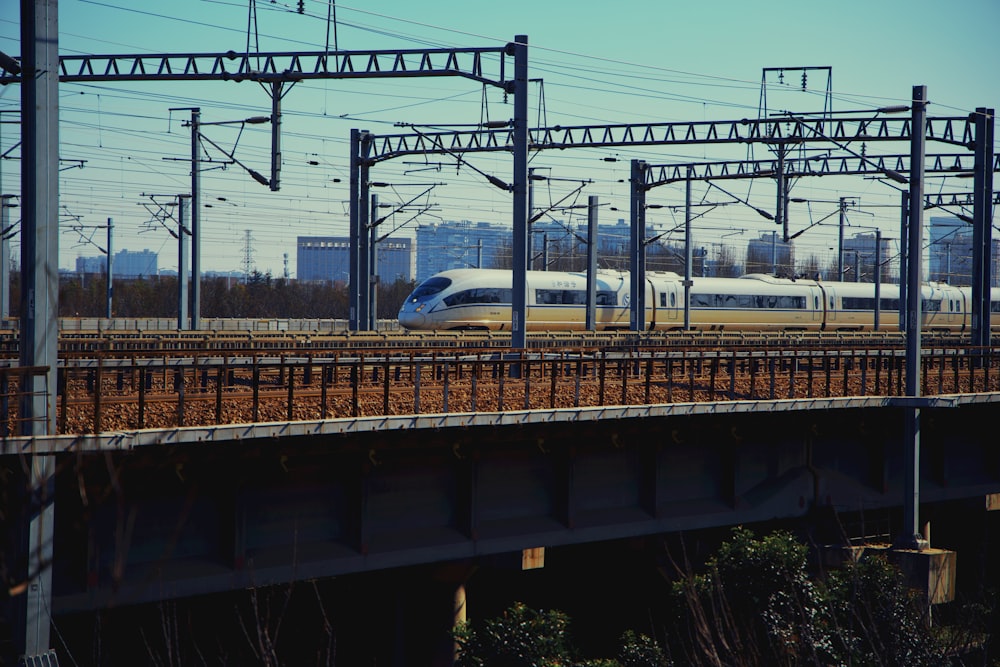 a train traveling down train tracks next to a bridge