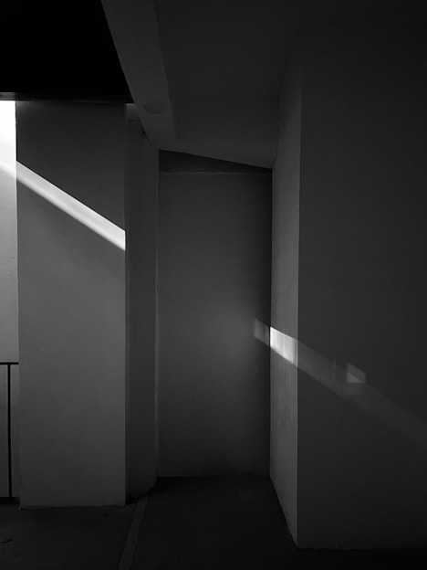 Black and white photo of a minimalist architectural space with soft natural light.
