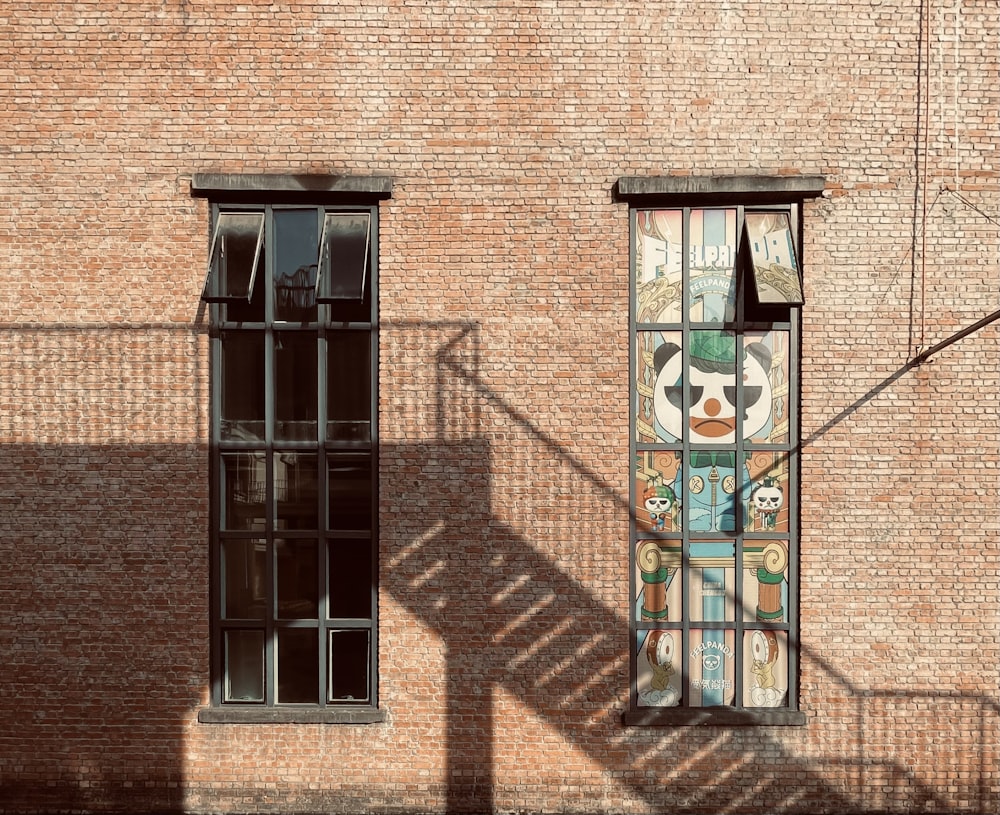 a brick building with a window with a mural on it