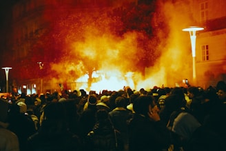 a large group of people standing around a fire