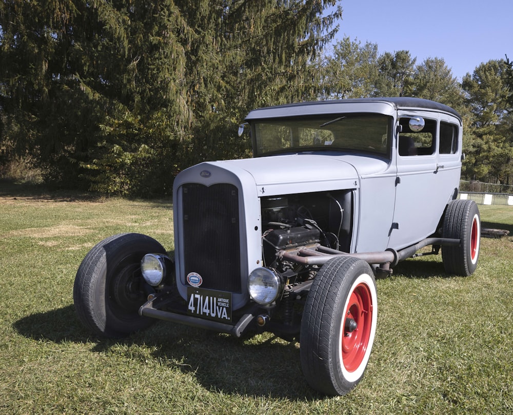 an antique car is parked in the grass