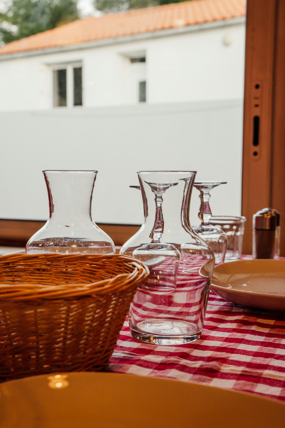 a table topped with glasses and plates on top of a checkered table cloth