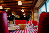 A cozy, rustic restaurant interior bathed in deep crimson and forest green tones.