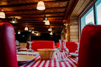 Cozy rustic restaurant interior with black and red decor and wooden stone elements.