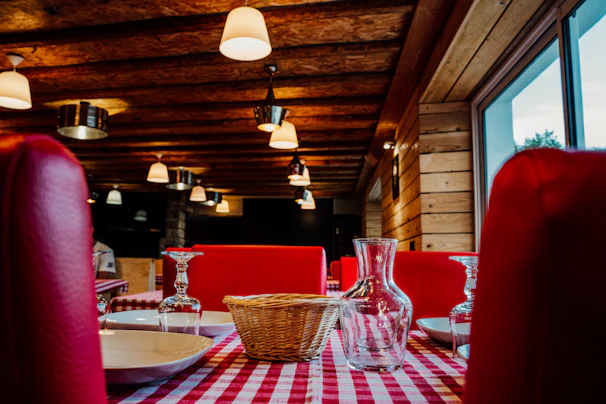Cozy rustic restaurant interior with black and red decor and wooden stone elements.