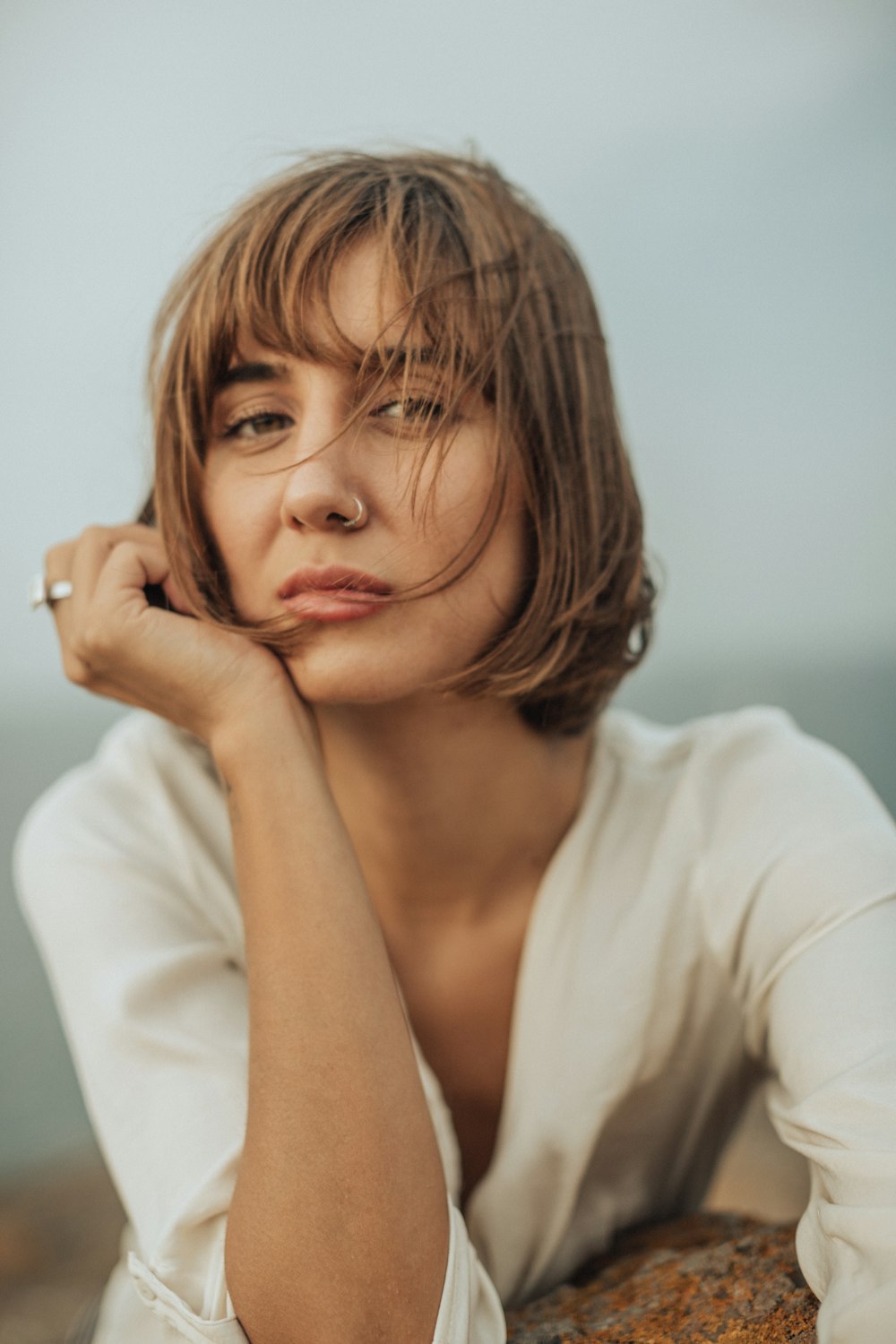 a woman sitting on top of a rock next to the ocean