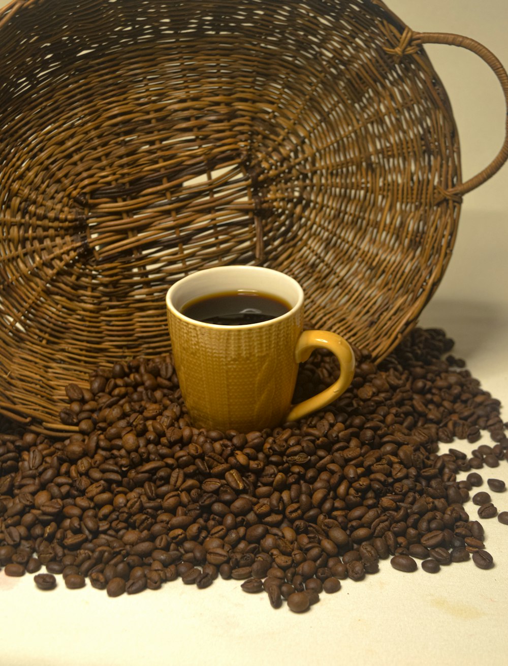 una taza de café encima de una pila de granos de café