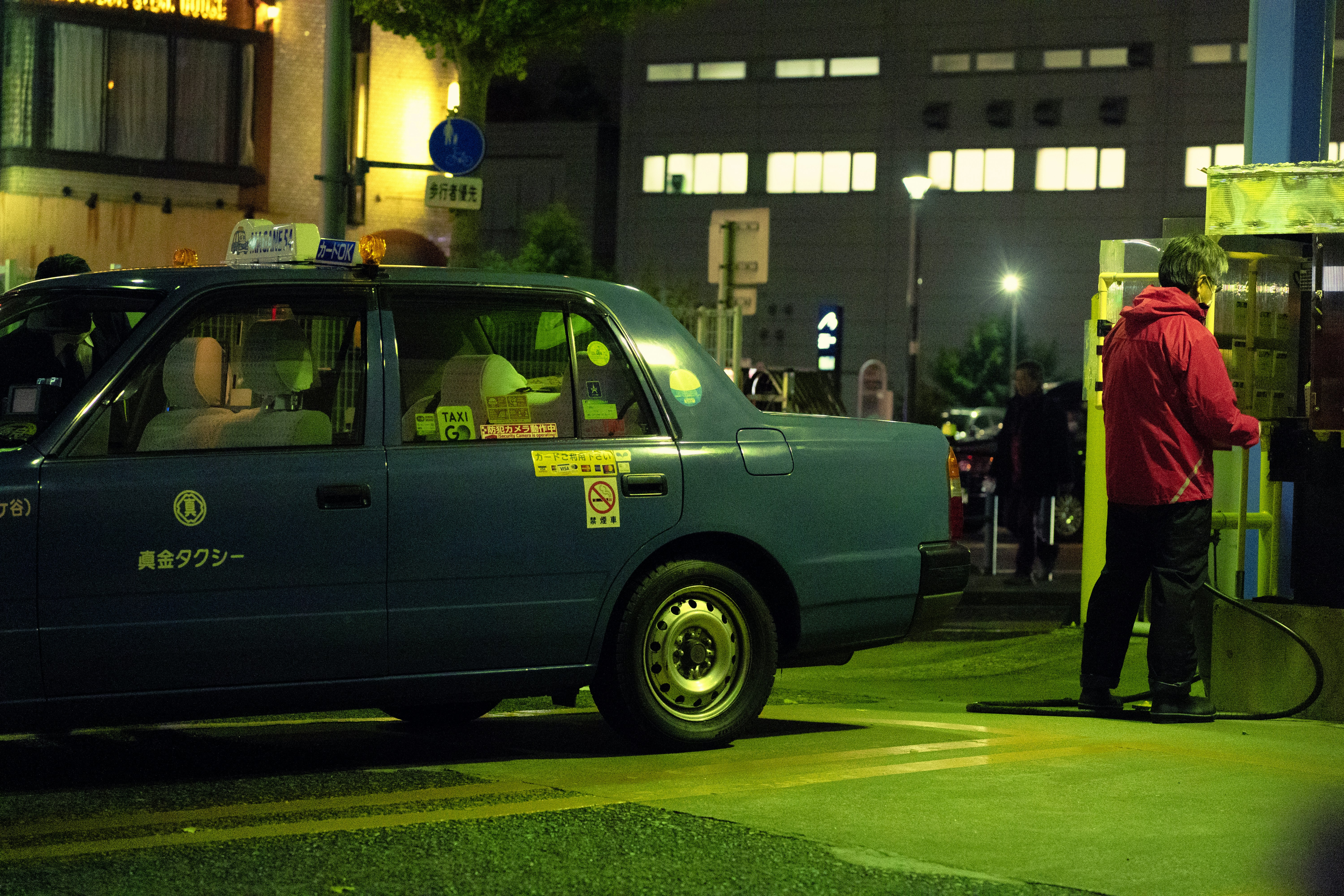 a blue taxi cab parked on the side of a road