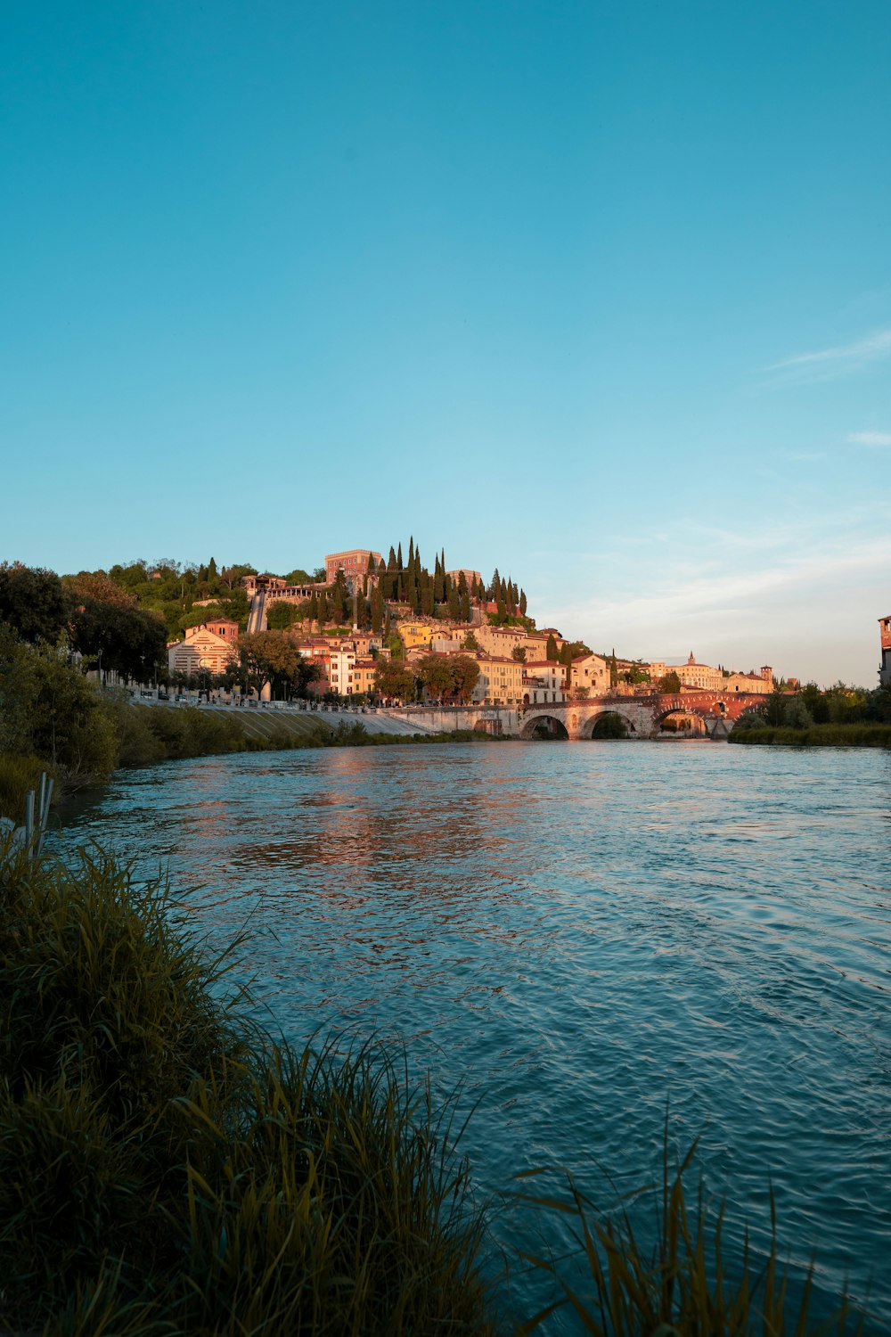 a body of water with buildings on a hill in the background