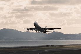 Airplane taking off from an airport with mountains in the background