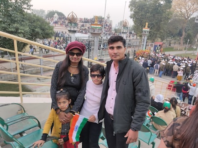 A happy family standing outside their new home in a vibrant Indian neighborhood.