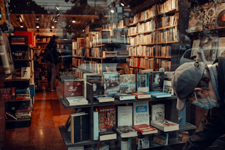 a man looking through a window at a book store