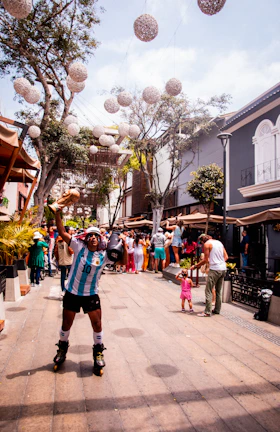 People dancing joyfully in the street wearing wireless headphones during a sunny day event