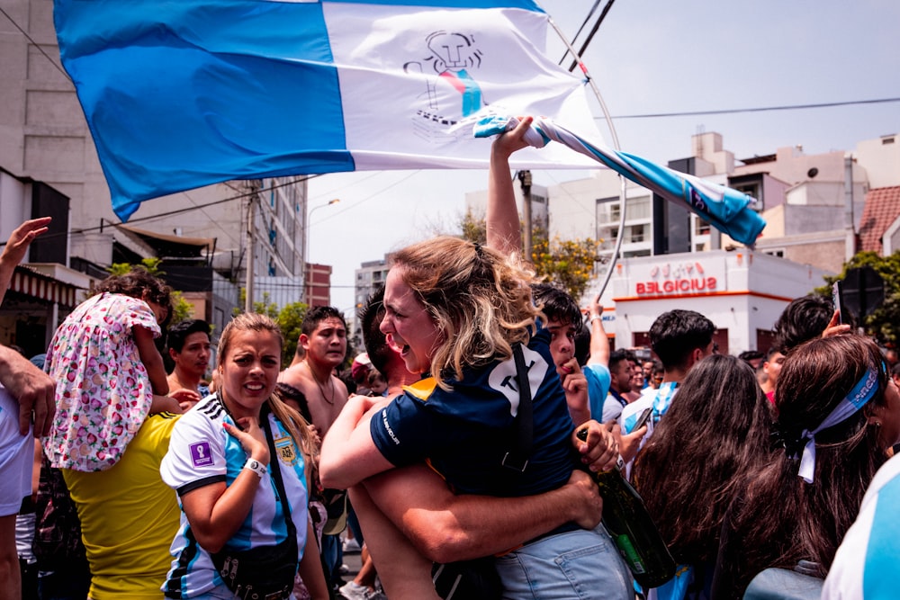 a woman holding a flag in the middle of a crowd