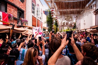 A lively outdoor event in Navarra with people enjoying and a camera crew filming.