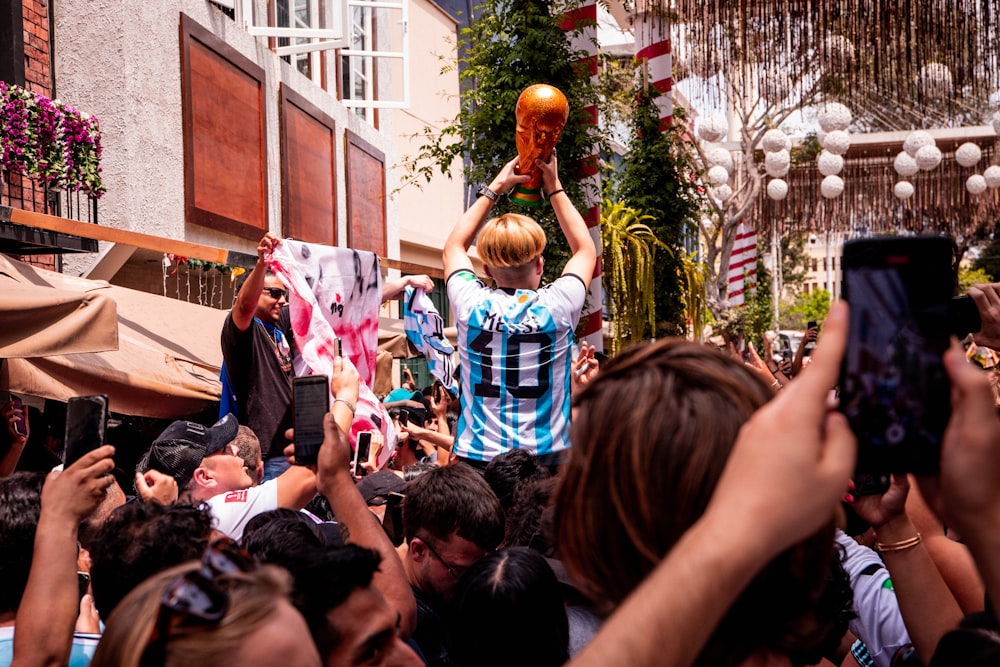 a crowd of people standing around a man holding a basketball