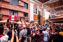 Group of enthusiastic fans wearing temporary flag tattoos at a lively outdoor event.