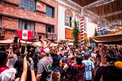 Group of enthusiastic fans wearing temporary flag tattoos at a lively outdoor event.