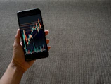Warm, cinematic photo of a trader analyzing signals with a terracotta-toned background.