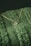 A close-up of an elegant pendant necklace displayed on a soft fabric background.