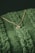 A close-up of a delicate gold necklace resting on a soft fabric background.