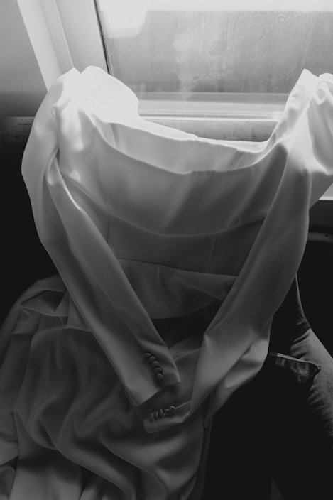 Delicate ivory silk nightgown draped softly on a vintage chair with natural light highlighting its smooth texture.