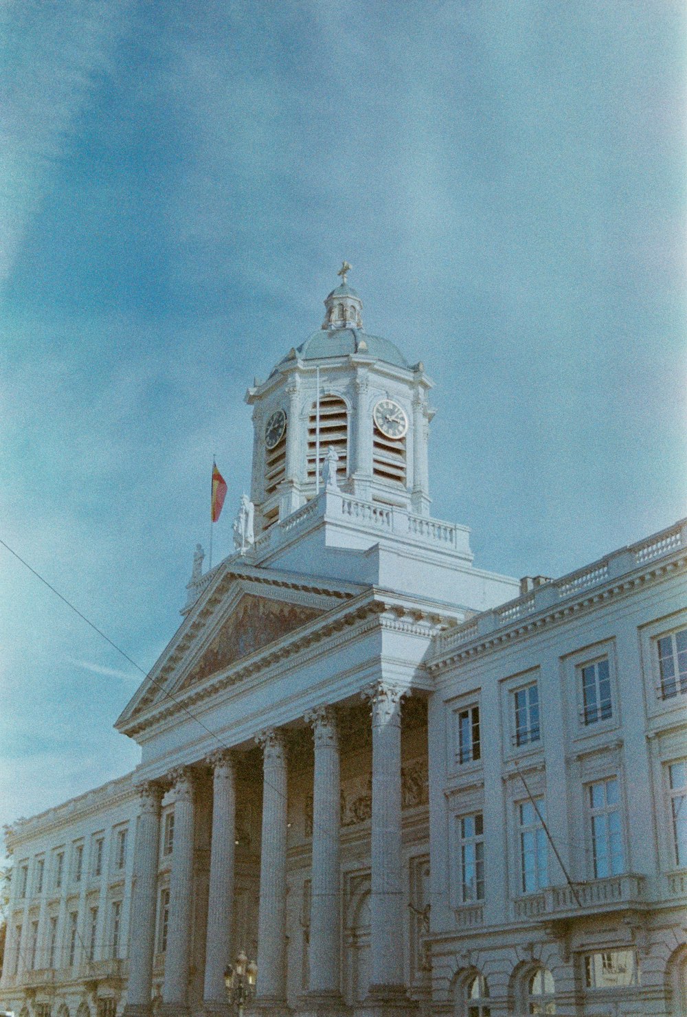 um grande edifício branco com uma torre do relógio