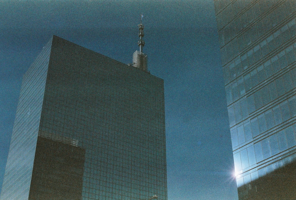 two tall buildings with a clock tower in the middle