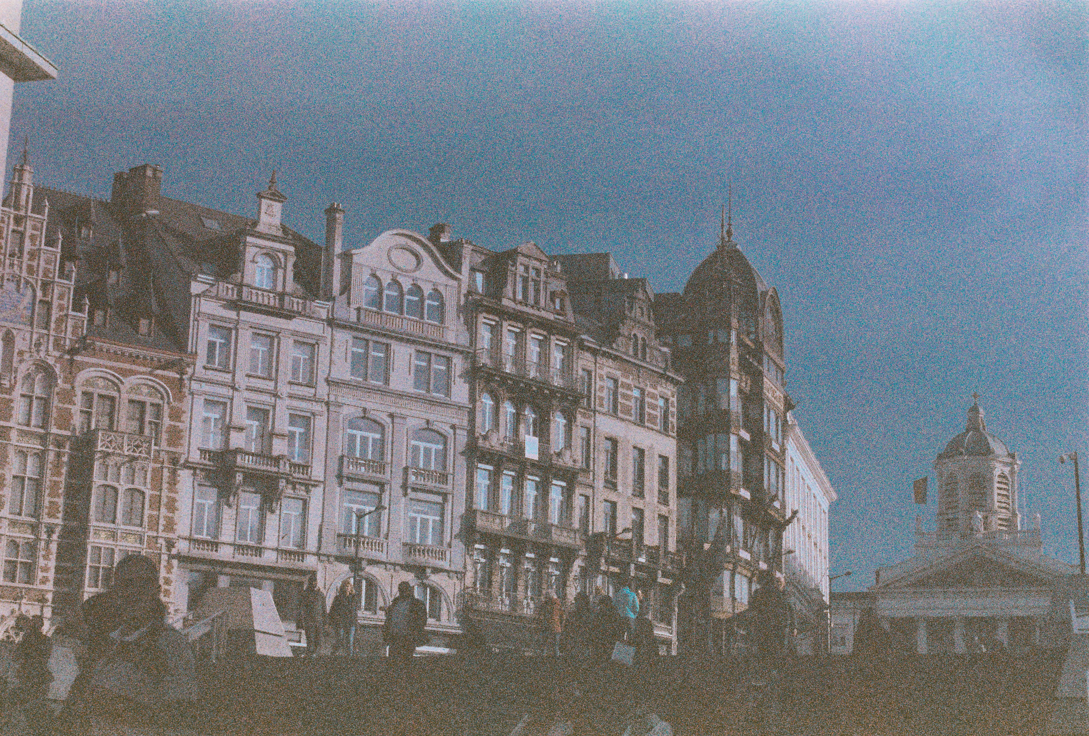 a group of buildings with a clock tower in the background
