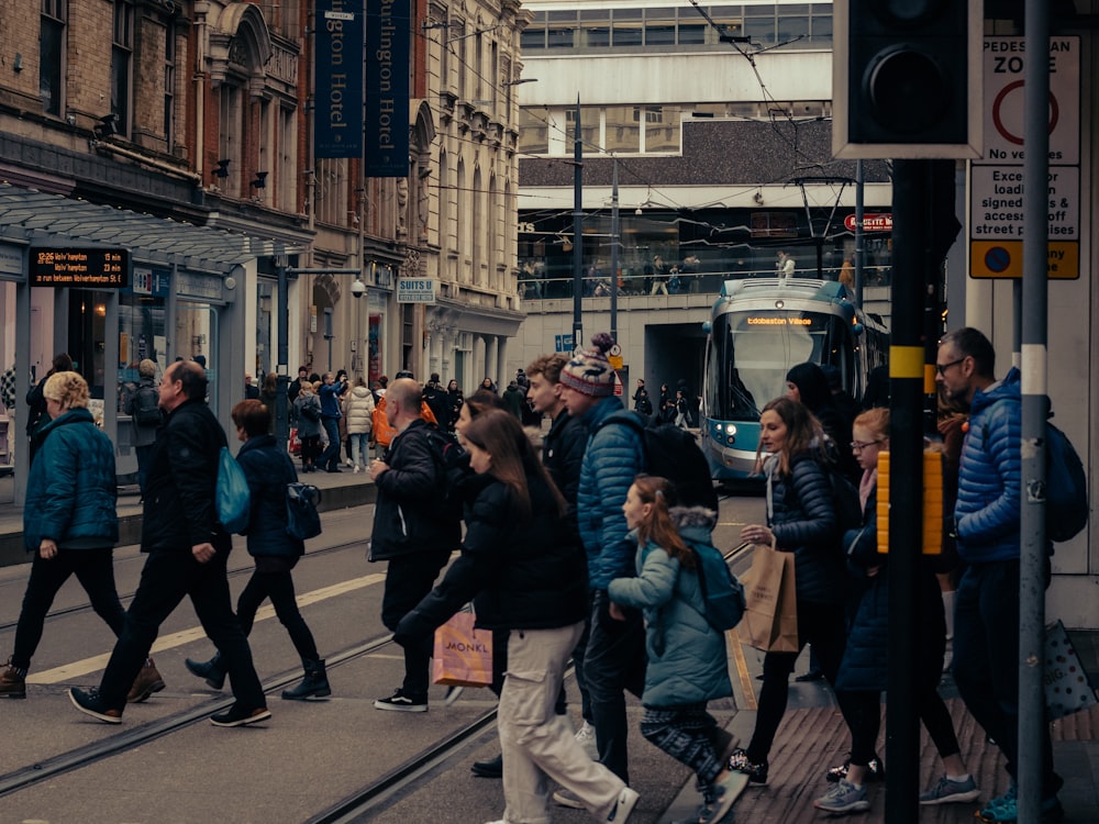 a crowd of people walking down a street next to tall buildings