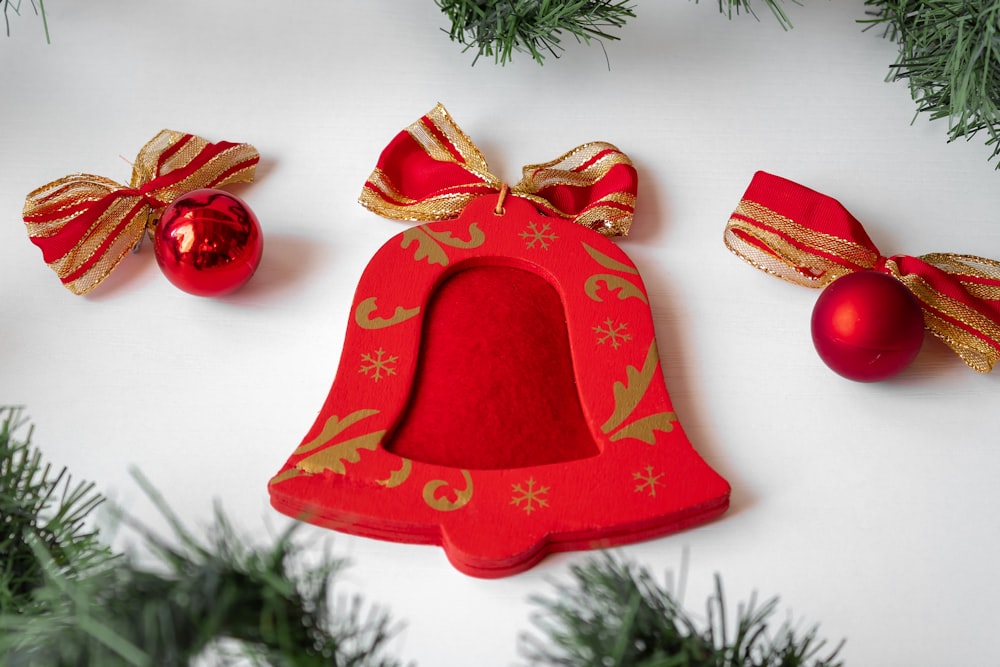 a red christmas ornament with a gold bow and a red ornament