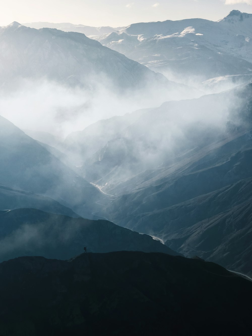 a view of a mountain range covered in clouds