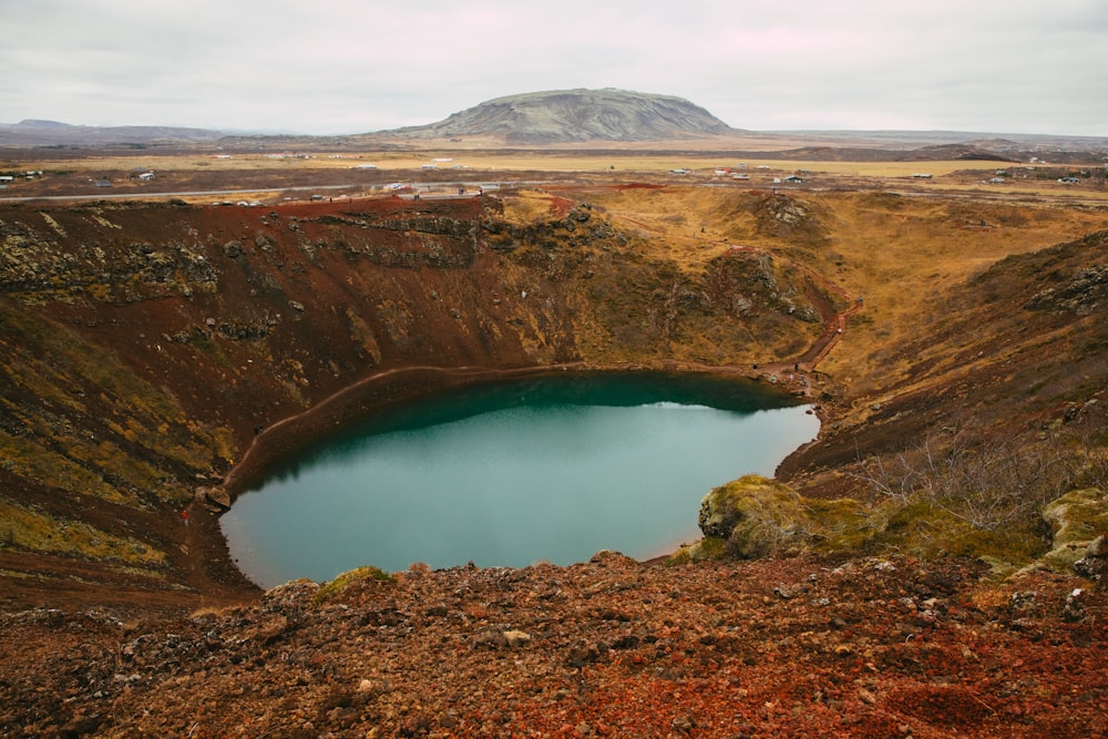 a large crater with a lake in the middle of it