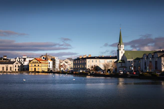 a body of water with a church steeple in the background