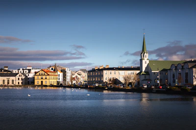 a body of water with a church steeple in the background