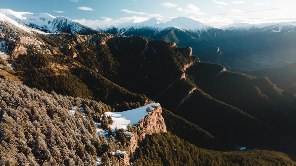 una veduta aerea di una catena montuosa con neve sul terreno
