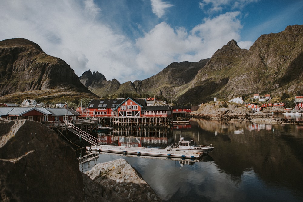 a boat is docked in the water next to a mountain