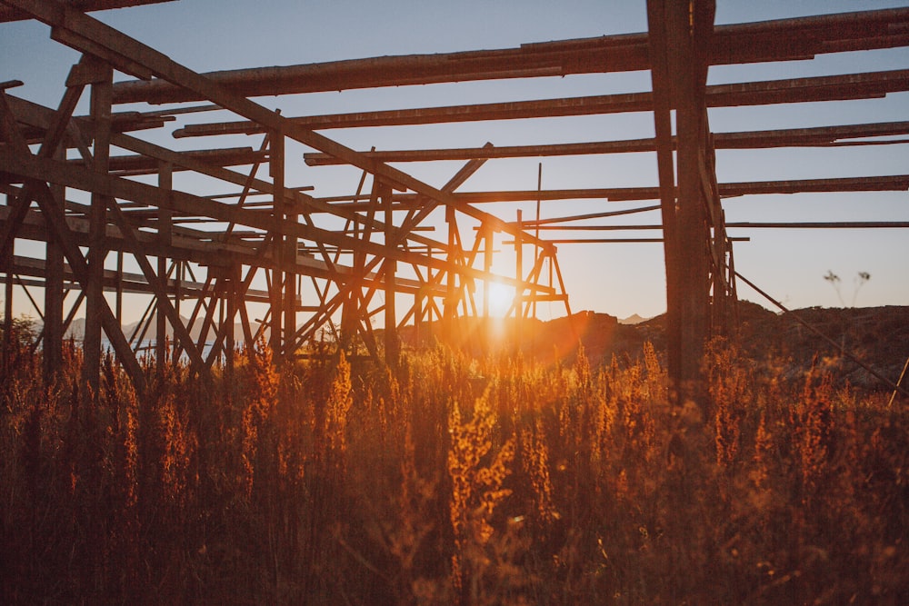 the sun is setting behind a wooden structure