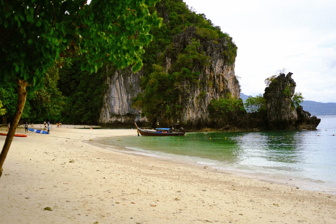 a sandy beach with a boat on the water,