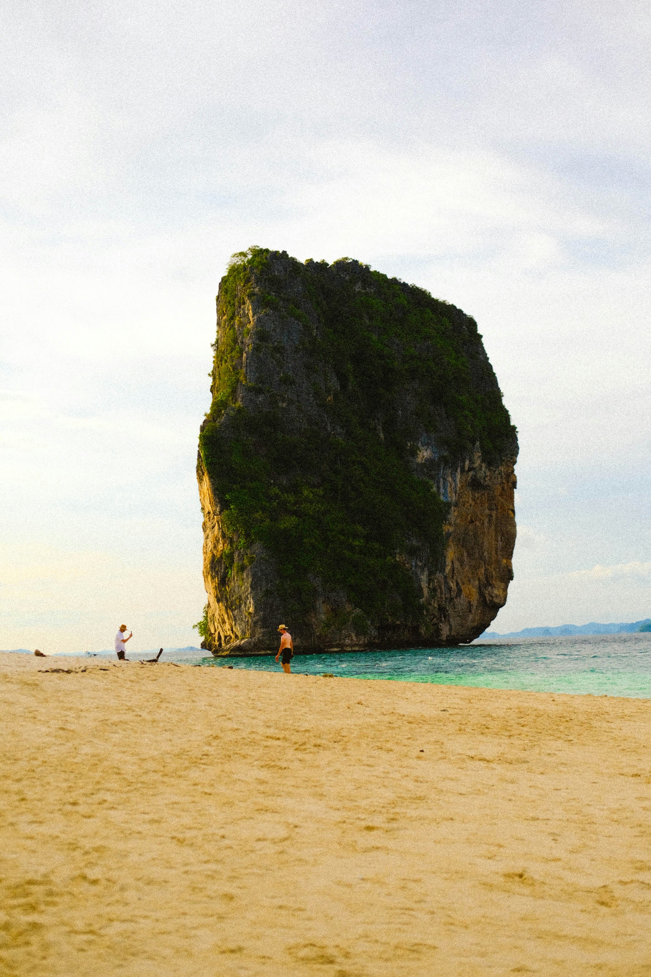 A large rock sitting on top of a sandy beach photo – Free Beach Image ...