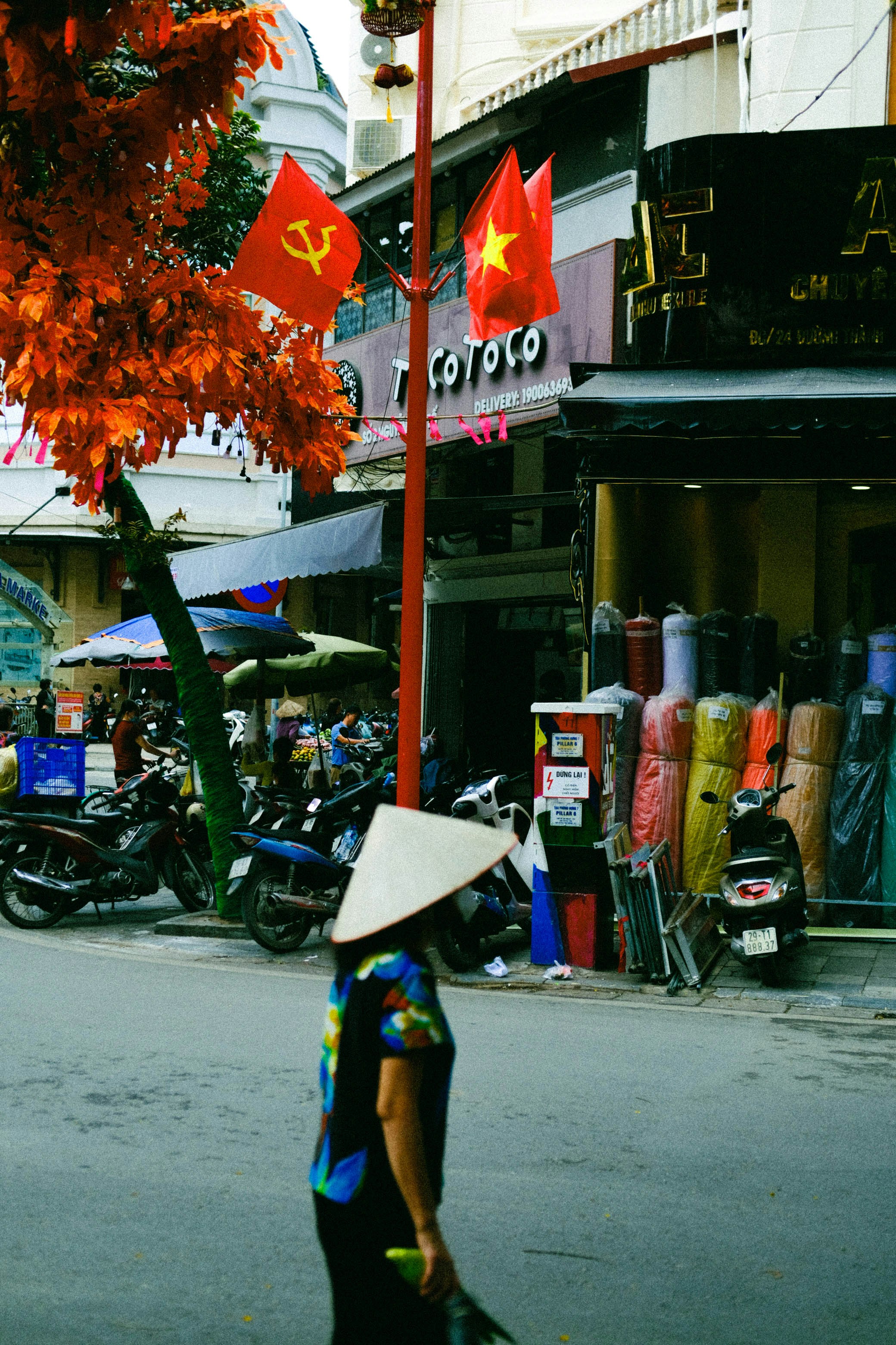 a woman walking down a street with a hat on her head