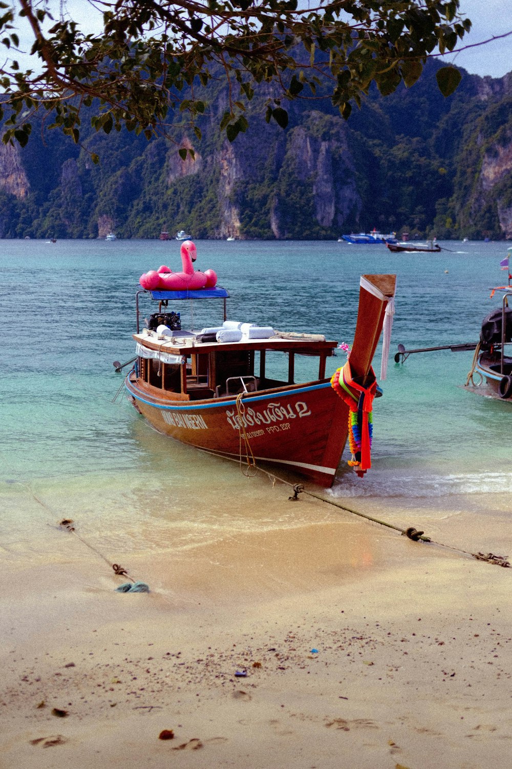 a boat is docked on the shore of a beach