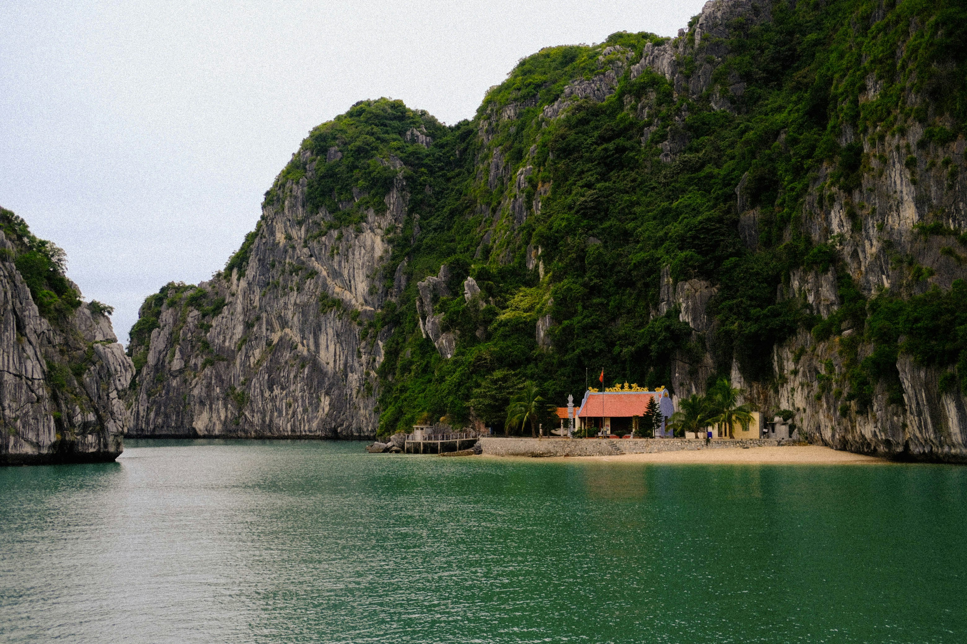 A house on the shore of a lake surrounded by mountains